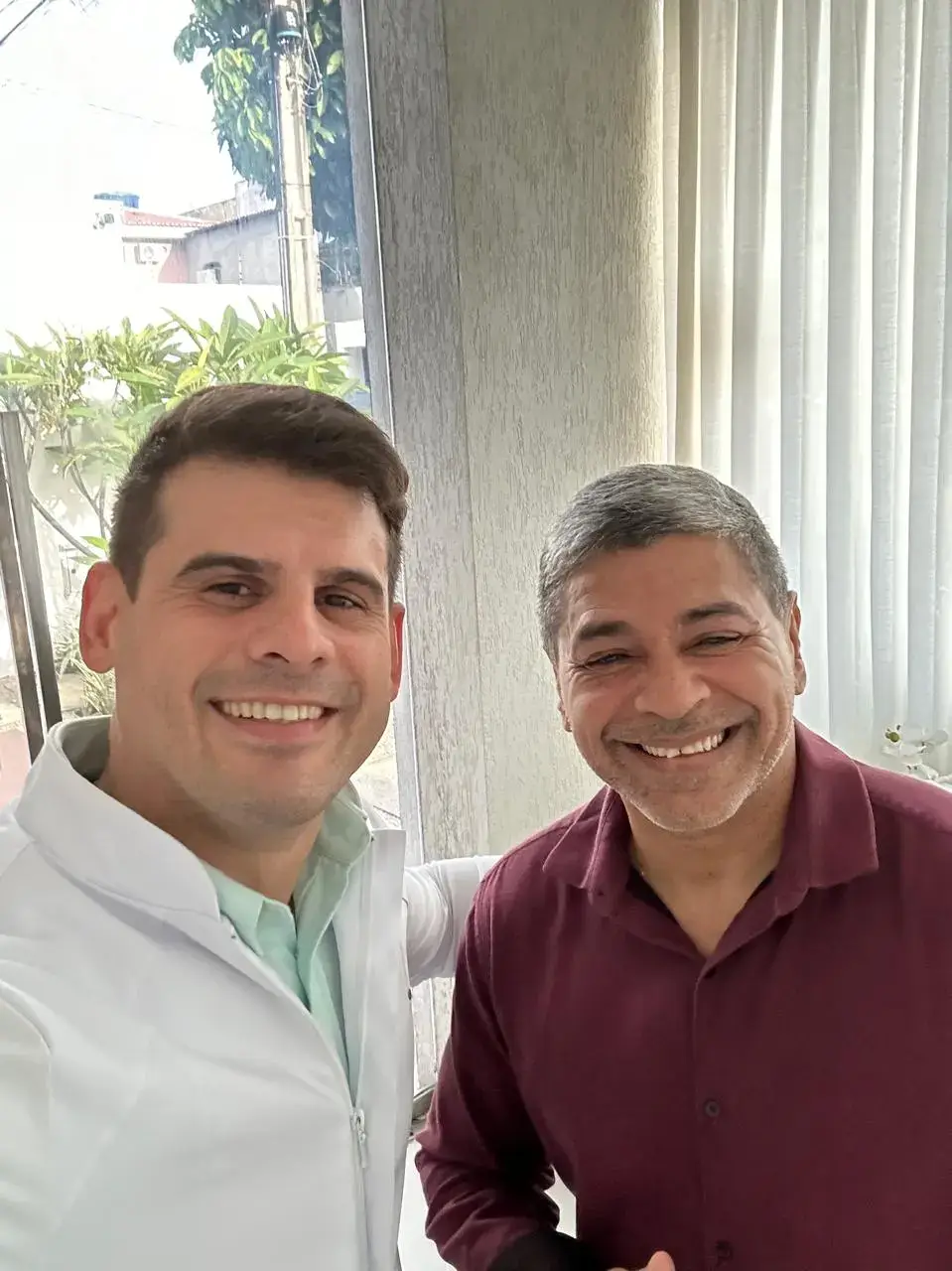 Dr. Carlos Nobre junto ao paciente sorrindo após ser curado da dor.