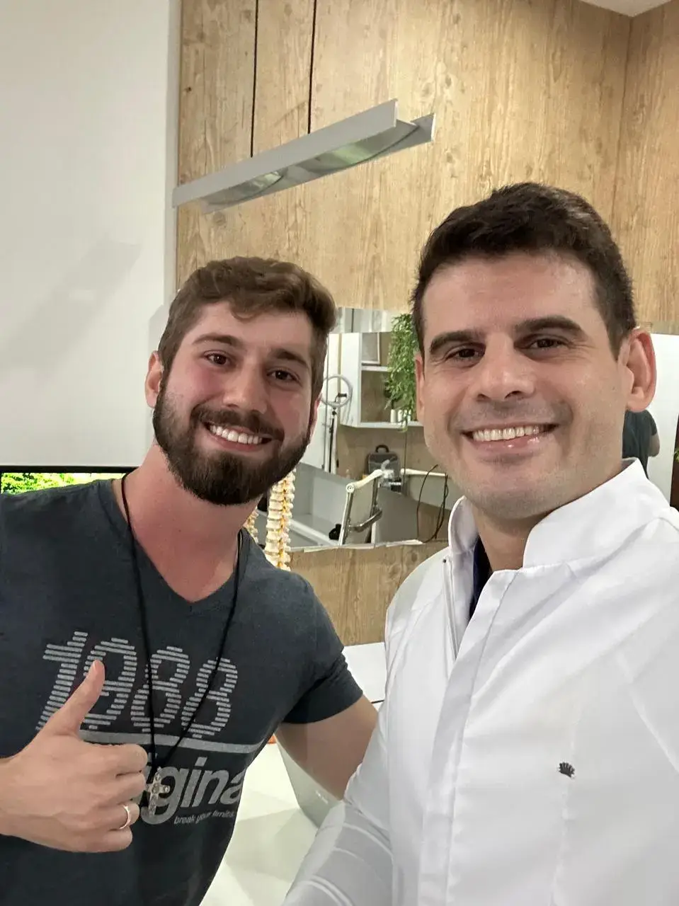 Dr. Carlos Nobre junto ao paciente sorrindo após ser curado da dor.