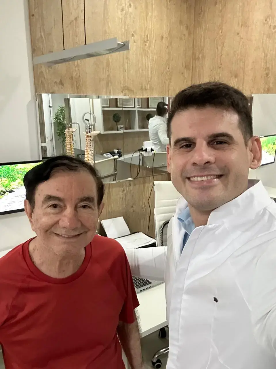 Dr. Carlos Nobre junto ao paciente sorrindo após ser curado da dor.